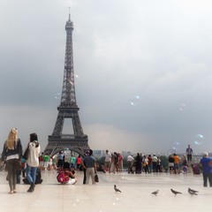 Fototapeta na wymiar Tourists At Eiffel Tower Against Cloudy Sky