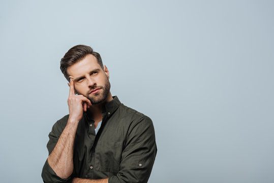 Dreamy Man With Finger Near Forehead Looking Away Isolated On Grey