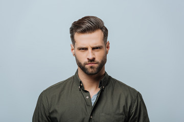 Obraz premium Serious man looking at camera isolated on grey