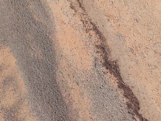 A drone shot over a dry orange beach with rocks. shot from above showing empty beaches due to the coronavirus lockdown. Orange dry desolate sands. Perfect fro mock ups and background texture.