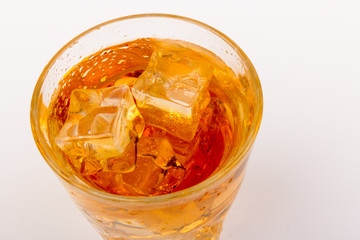 Glass of scotch whiskey and ice over white background.