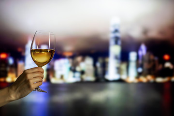 Hand held a glass of wine under evening light