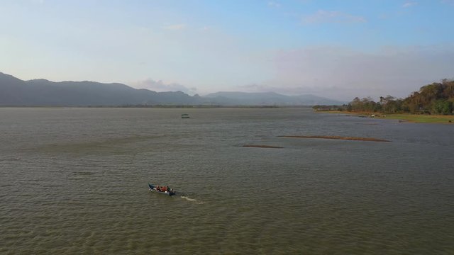 February 29th, 2020 - Perlis, Malaysia : 4k Establishing Aerial View of A Boat Cruising in Timah Tasoh Lake side During Beautiful Sunset. Mountain view in Background. Drone Tracking Right