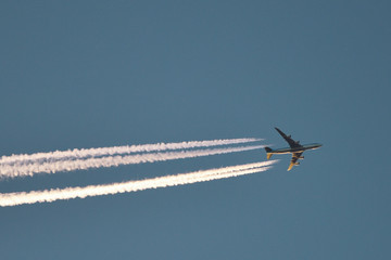 Airplane With Plane Trails at sunset
