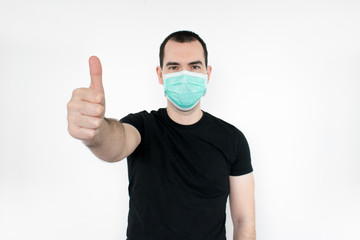 caucasian male man young. standat white background, wear mask on face,   thumbs up gesture one hand,  protect yourself, safe people. Coronavirus.