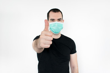caucasian male man young. standat white background, wear mask on face,   thumbs up gesture one hand,  protect yourself, safe people. Coronavirus.