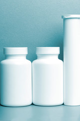 photo of three plastic cans for package pills and vitamins  for protection against coronavirus KOVID-19 on a blue background. photo without bottle labels