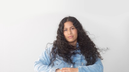 Mixed race plus size woman without makeup in studio watching to the camera blowing long hair