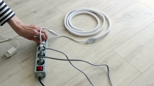 Man pulls outlets from an extension cord.