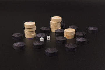 Backgammon. Board game. White cubes and chips on a blackboard.  Dice on backgammon board game. Playing leisure games