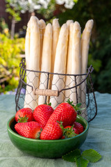 Dutch farmers products, fresh white asparagus and red ripe strawberry in spring sunny garden