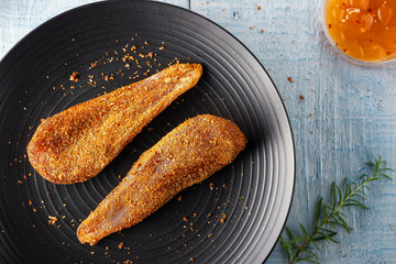 Seasoned chicken with hot sauce and a sprig of rosemary