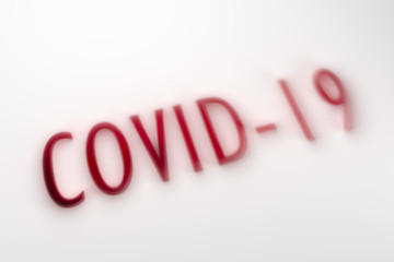 Covid - 19 word in red shadow on a white shaded background. 