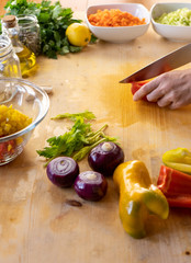 Moments of daily life in the Mediterranean cookery: low angle view of a young female cook cutting a...