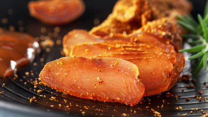 Seasoned chicken with hot sauce and a sprig of rosemary