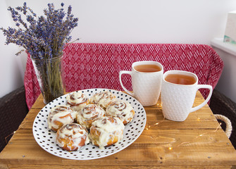 Fresh and fragrant cinnamon rolls, two cups of black tea.