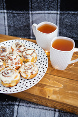 Fresh pastries, cinnamon rolls. Two cups of black tea.