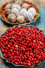 Bowl with dried red round peppers and nutmegs