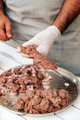 Process of making kebab. Meat on skewer. Cooker follow hygiene and use gloves. Mixed grill. Traditional arabic dish. Family dinner. Real photos of cooking