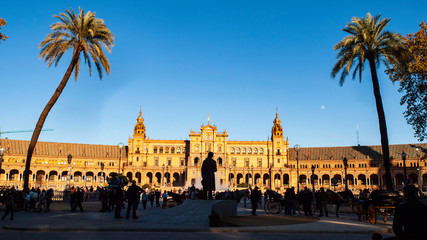 Panorámica de la Plaza de España de Sevilla con la estatua de Aníbal Gonzalez entre dos grandes palmeras