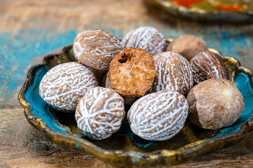 Dried nutmegs nuts in vintage bowl