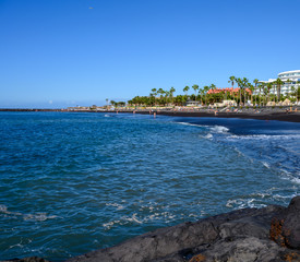 Naklejka na ściany i meble All year sun vacation destination, blue ocean water on beach Playa del Duque in Costa Adeje, Tenerife island, Canary, Spain