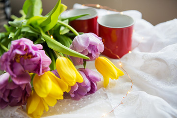 Beautiful morning, two cups of coffee and a bouquet of bright tulips.