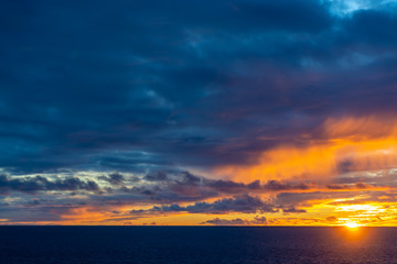 Amazing sunset with colorful clouds and dark ocean water, nature background