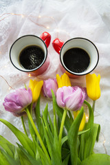 Fototapeta na wymiar Beautiful morning, two cups of coffee and a bouquet of bright tulips.