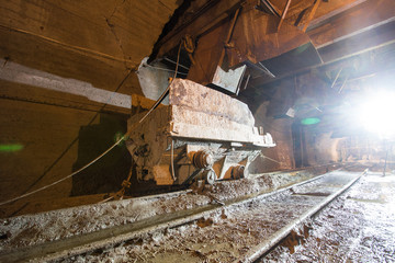 Mining carts wagons with ore in gold mine underground tunnel