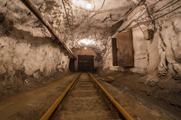 Fototapeta na wymiar Underground gold mine shaft tunnel drift with rails and doors