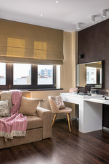 Interior photo. Space for work away. A cozy sofa and a workplace - a white table, a chair and a laptop. Telework