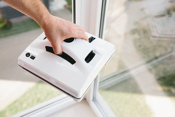 
Vacuum robot for cleaner windows in men's hands. Stylish automatic glass and window cleaner.