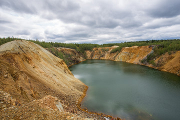 Flooded copper pyrite open pit quarry with green water lake