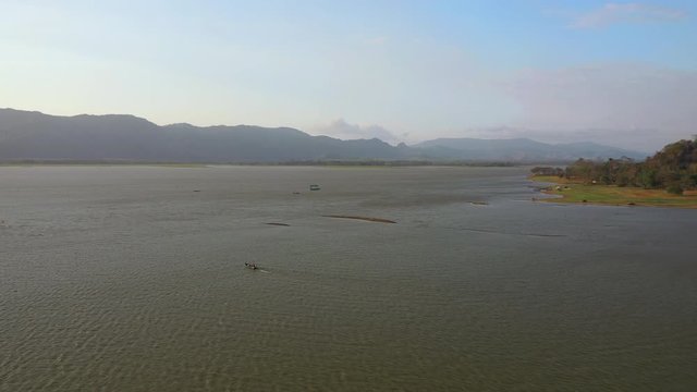 February 29th, 2020 - Perlis, Malaysia : 4k Establishing Aerial View of A Boat Cruising in Timah Tasoh Lake side During Beautiful Sunset. Mountain view in Background. Drone Moving forward 