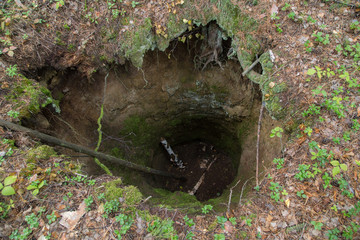 Old abandoned mine open pit in forest