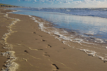 Fußspuren und Wellen am Strand