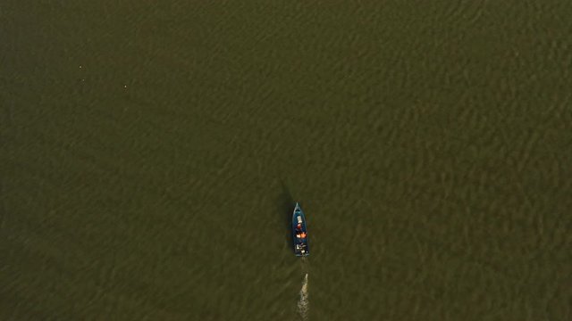 February 29th, 2020 - Perlis, Malaysia : 4k Establishing Aerial View of A Boat Cruising in Timah Tasoh Lake side During Beautiful Sunset. Mountain view in Background. Top down Shot.