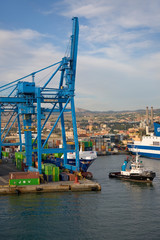 Tug boat pulling cargo ship to sea at Port of Civitavecchia, Italy, the Port of Rome