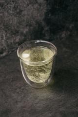Effervescent vitamin c tablet in a glass goblet on a gray stone background. Prevention of flu and colds, strengthening immunity against viruses