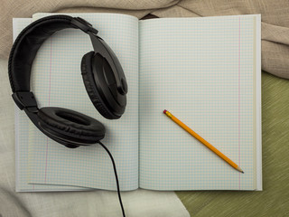 Notebook with pencil and headphones