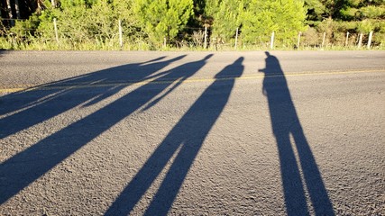 sombra de pessoas na estrada