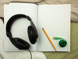 Notebook with pencil and headphones