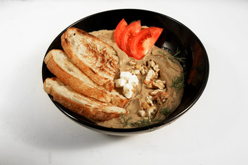 pate tomatoes toasts on a black plate on white background 