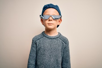 Young little caucasian kid wearing internet meme thug life glasses over isolated background with...