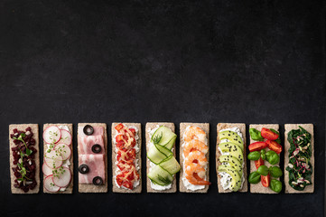 different sandwiches on a black background. Top view, place for text.