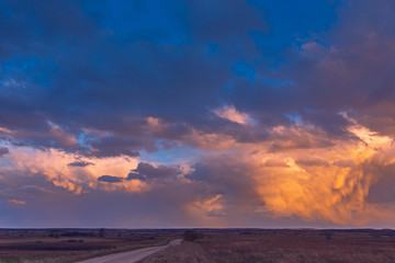 Fototapeta na wymiar Path to cumulonimbus red storm clouds at sunset, beautiful landscape