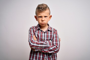 Young little caucasian kid with blue eyes wearing elegant shirt standing over isolated background skeptic and nervous, disapproving expression on face with crossed arms. Negative person.