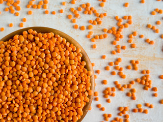 Healthy eating and dietary. Bowl of raw red lentil on white wooden background. Top view. Flat lay. Masoor Dal or Canadian Orange Lentils. Vegetarian super food.