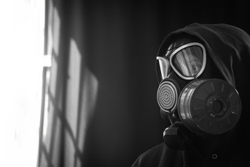 The girl is wearing a military gas mask. Isolated on a black background. Respiratory protection...